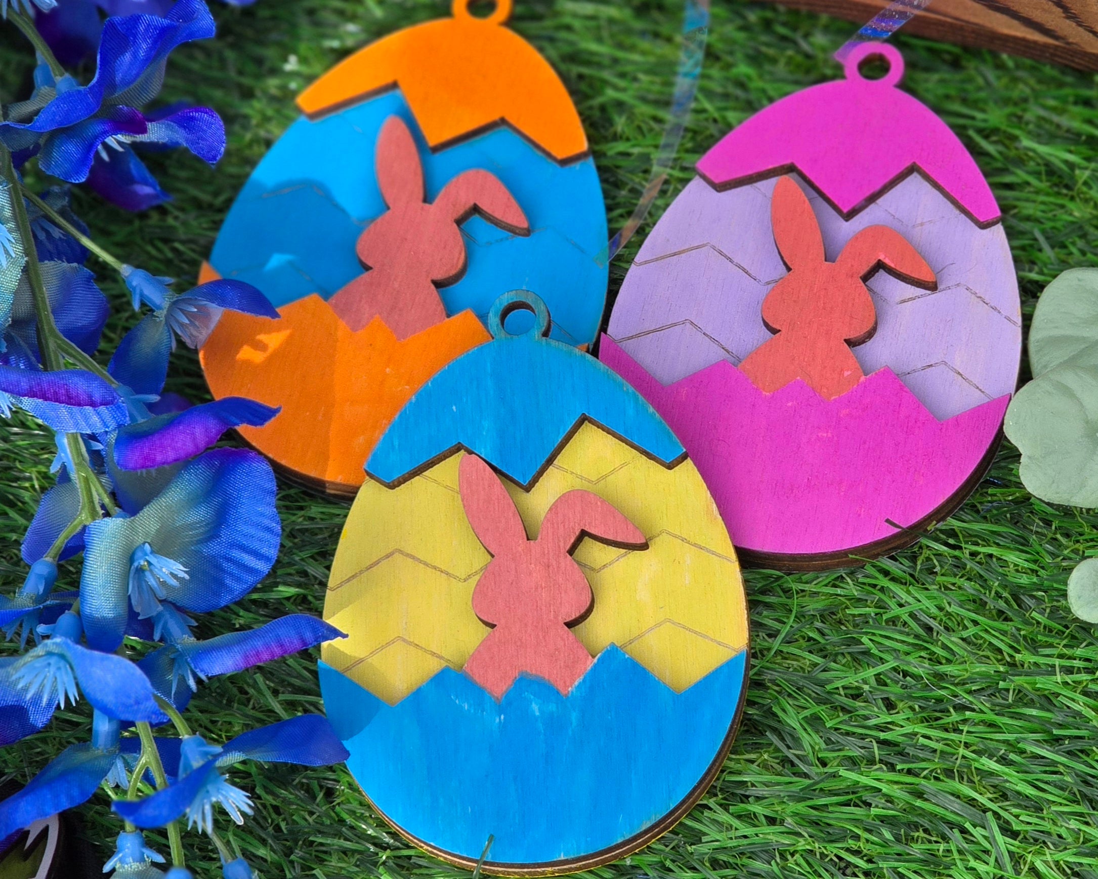 Colorful Easter egg-shaped decorations with bunnies on a grass background